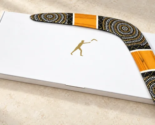 Illustration of a Golden Sun wooden boomerang on a white gift box with a gold logo.