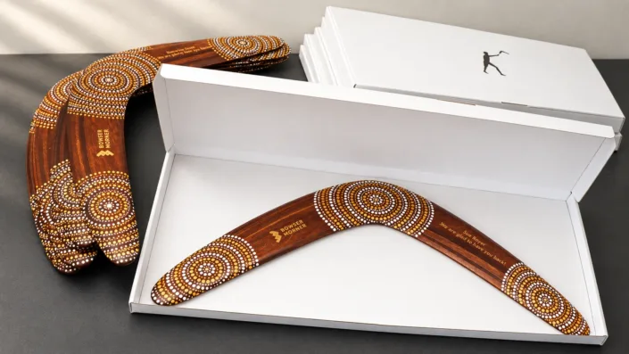 Personalized boomerangs with white gift boxes — illustration Illustration of a Bowser Morner boomerang in an open white gift box beside matching products and boxes.
