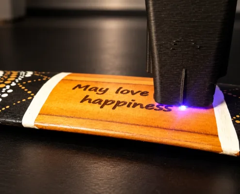 Illustration of a Golden Sun boomerang being personalized with a laser engraver.