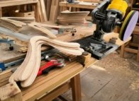 Crafting Authentic Wooden Boomerangs Workshop view showing stacks of raw birch plywood cutouts and sanding tools used to handcraft real wooden boomerangs.